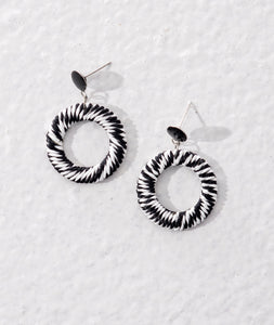 Monochrome earrings made of raffia wrapped around metal rings. Sustainable natural materials used.