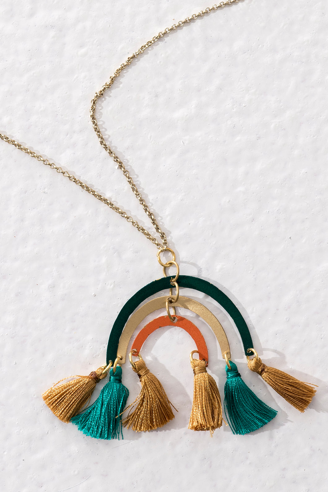 Ethical long necklace with brass rainbow-like pendant and multi-coloured tassels. Handmade in India.