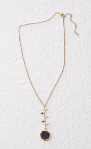 Reversible fairtrade necklace that has a purple and a white side. Ethically made sustainable fashion