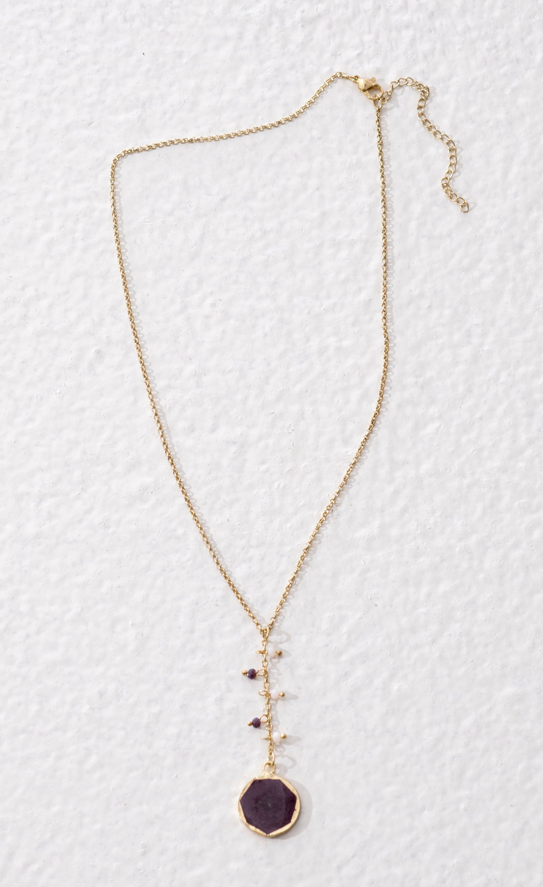 Reversible fairtrade necklace that has a purple and a white side. Ethically made sustainable fashion